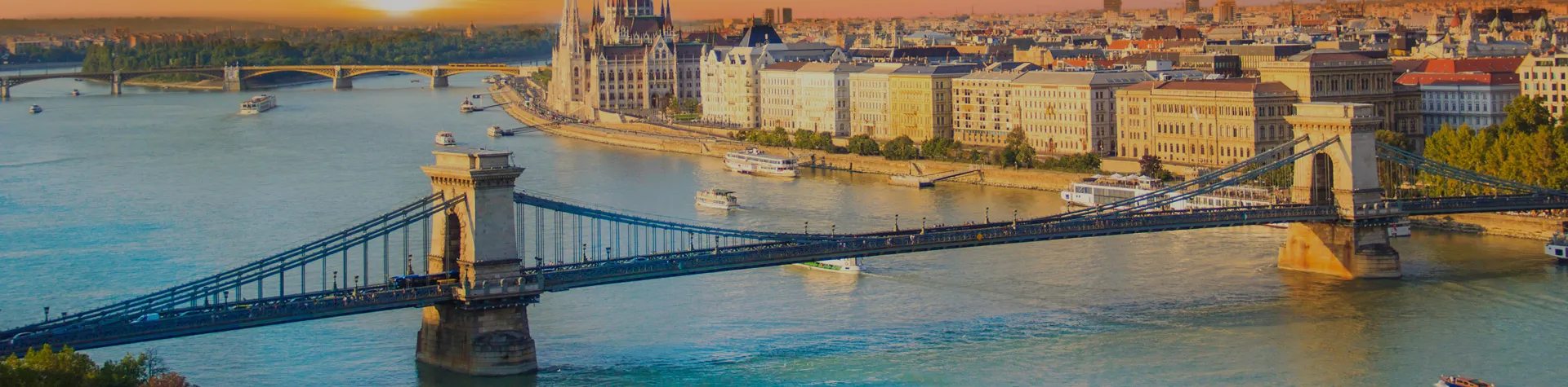 Budapest vid solnedgången, med Kedjebron och ungerska parlamentet längs Donau.