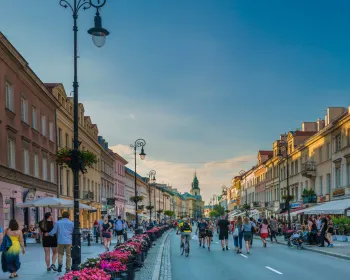 Krakowskie Przedmieście med historiska byggnader, kaféer och livlig atmosfär.